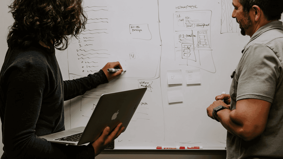 Person at whiteboard planning with a colleague